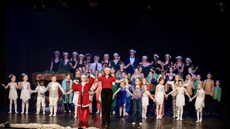 Große Bühnenszene mit Kindern und Erwachsenen in Weihnachtskostümen, Nikolaus und Elisabeth Hübert in der Mitte, festliche Adventsshow.