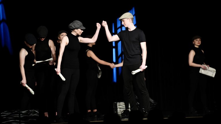 Theateraufführung "All Together Now" mit Schülern der Musicalschule Ahrensburg auf der Bühne in schwarzer Kleidung.