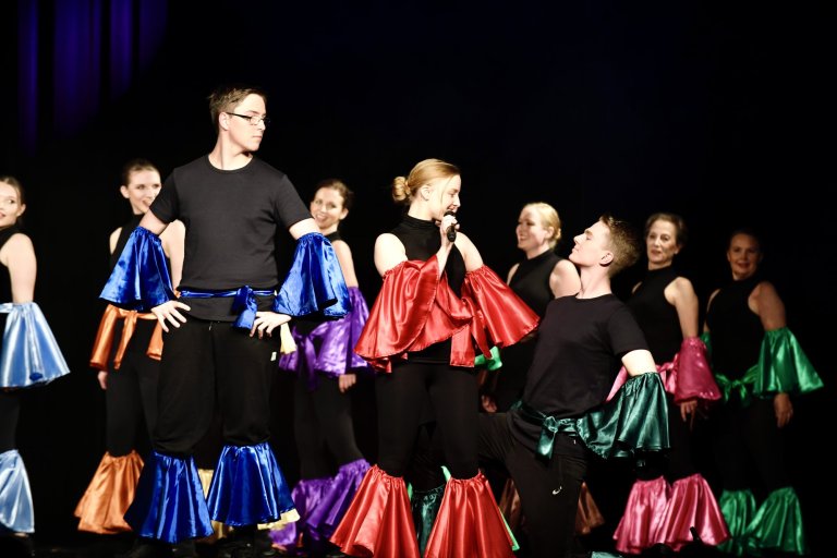 Musicalschüler auf Bühne in bunten Umhängen singen gemeinsam beim Schulmusical "All Together Now" Ahrensburg.