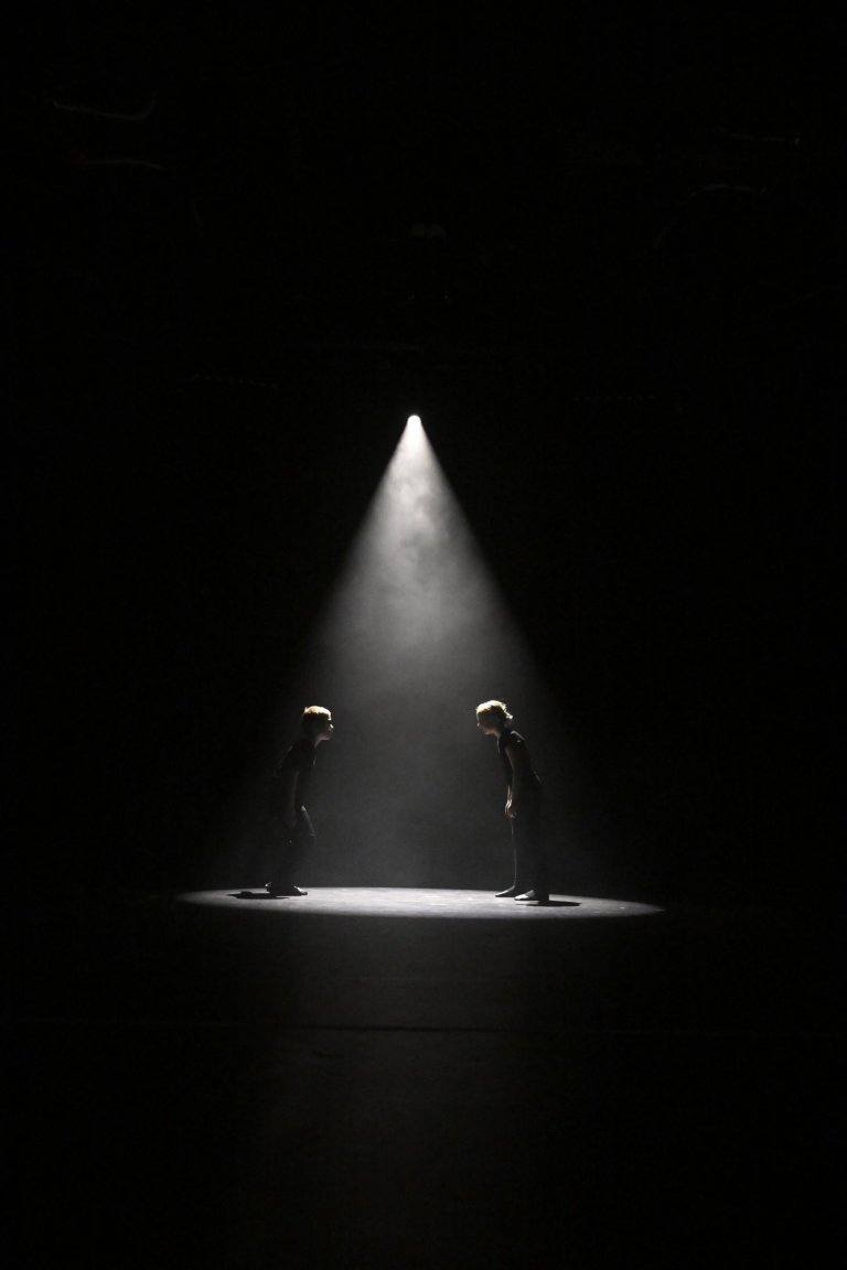 Zwei Performer auf dunkler Bühne im Scheinwerferlicht, dramatische Theaterszene der MSA10-Jubiläumsshow.