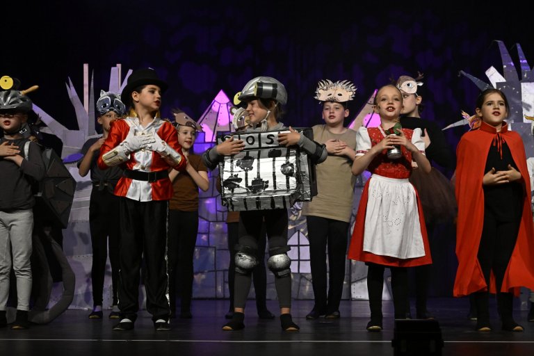 Kindermusicalgruppe auf Bühne mit bunten Kostümen und Requisiten zur Jubiläumsshow MSA10.