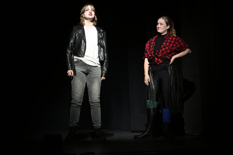 Zwei junge Darsteller auf dunkler Bühne in Lederjacke und kariertem Hemd während MSA10 Jubiläumsshow.
