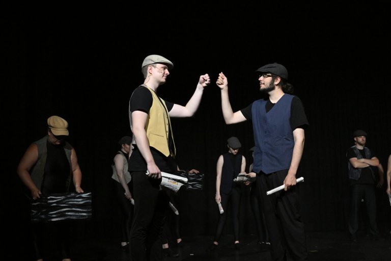 Schüler der Musicalschule Ahrensburg präsentieren Jubiläumsshow MSA10! mit Tanzszene und Schauspiel auf dunkler Bühne.