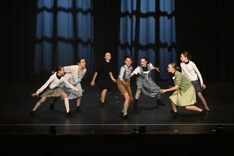 Sieben junge Darsteller tanzen energiegeladen auf der Bühne bei der MSA10 Jubiläumsshow der Musicalschule Ahrensburg.