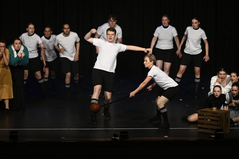 Jubiläumsshow MSA10: Junge Darsteller in weißen Shirts spielen Fußball auf Theaterbühne mit Publikum.