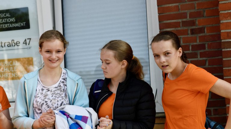 Drei Schülerinnen der Musicalschule Ahrensburg mit Trainerin besprechen Choreografie und Bewegungsabläufe.