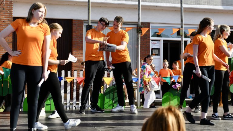 Musicalschüler in orangenen Shirts präsentieren beim MSA Sommerfest 2022 eine Aufführung vor Publikum auf der Außenbühne.