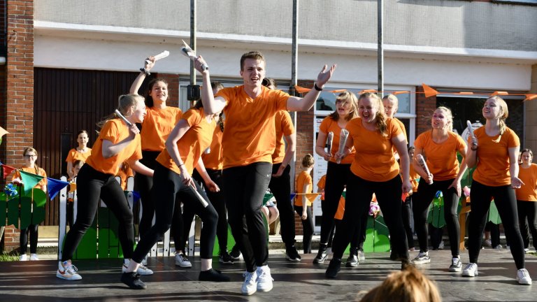 Tanzgruppe in orangenen Shirts führt choreografierte Performance beim MSA Sommerfest 2022 auf Schulhof auf.