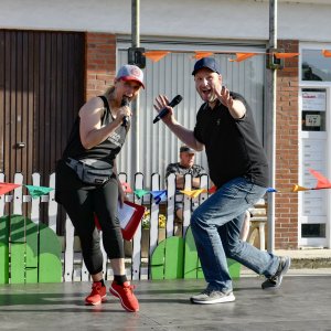 Zwei Moderatoren mit Mikrofonen beim MSA Sommerfest 2022, energisch auf der Bühne vor begeistertem Publikum.