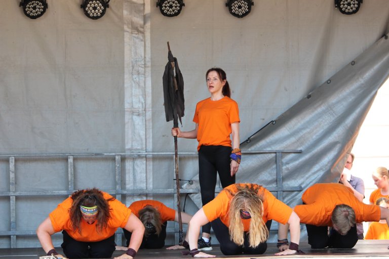 Musicalschüler in orangenen Shirts führen Choreografie auf Bühne beim Lindenfest Ludwigslust auf.