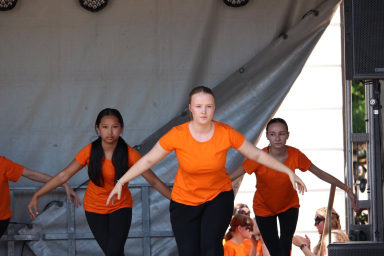 Drei Schülerinnen der Musicalschule Ahrensburg performen synchron mit ausgestreckten Armen auf der Lindenfest-Bühne Ludwigslust.
